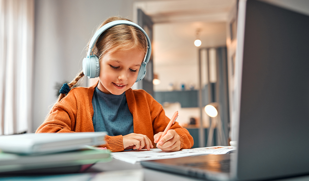 Criança estudando com computador.
