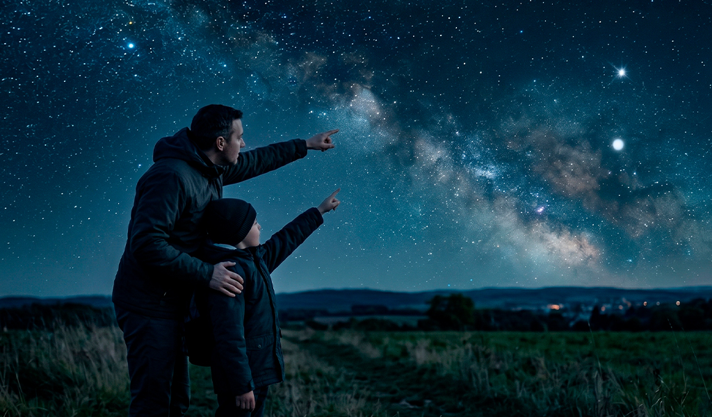 Pai e filho observando estrelas noturnas