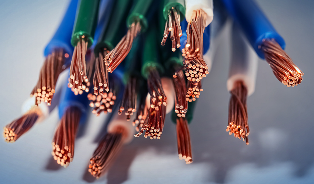 Imagem aproximada de cabos elétricos com filamentos de cobre expostos.